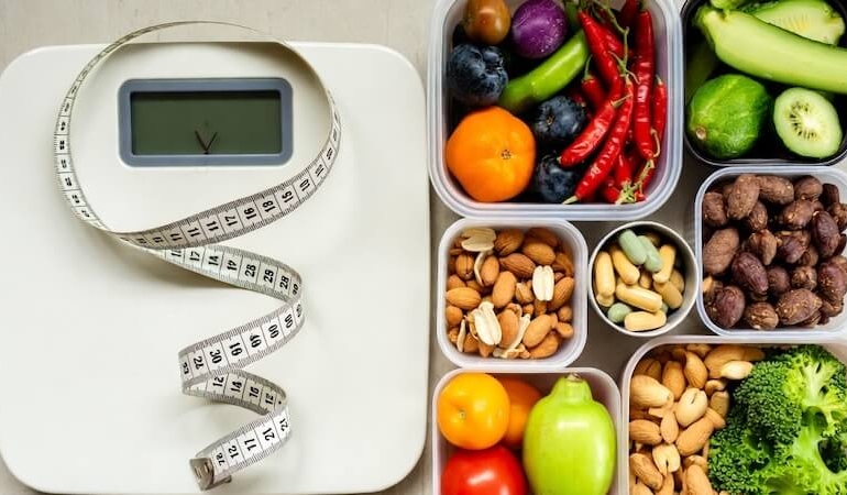 Sağlık alışverişi sepeti yanında mezura, tartı ve vitamin kutuları ile vücut analizi konsepti.